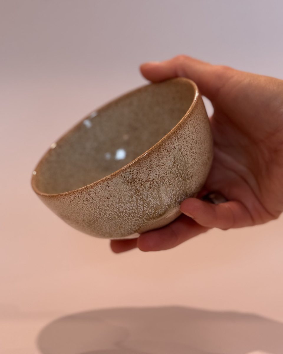 A speckled oatmeal bowl held in one hand